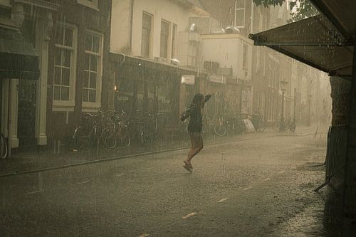 Jonge vrouw danst in de regen