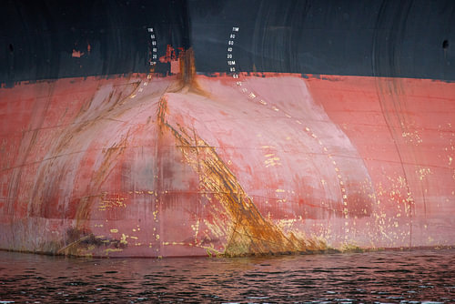 The bow of a seagoing vessel bearing traces of the sea