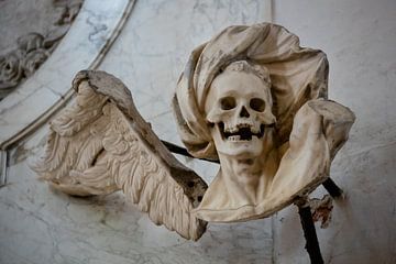Beeld van engel met doodshoofd schedel, Lübeck, Duitsland van Joost Adriaanse