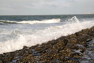 Water van de Noordzee bots tegen de rotsen van de Zeeuwse kust op een winderig dag van Robin Verhoef