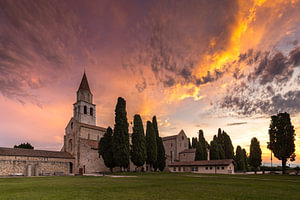 Basilika von Aquileia unter einem farbenprächtigen Morgenhimmel
