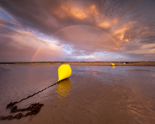 Een boei tijdens laag water op het strand