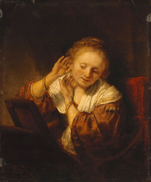 Junge Frau, die Ohrringe anprobiert - Rembrandt van Rijn von Rembrandt van Rijn