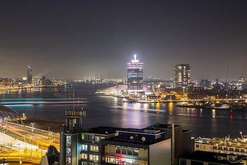 Pontjes in de avond trekken lijnen op het IJ in Amsterdam