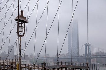 Mistig uitzicht vanaf The Brooklyn Bridge in New York van Marieke van de Velde