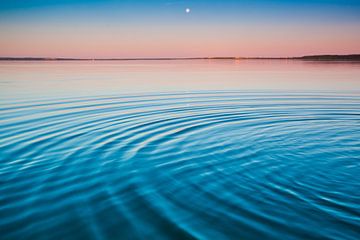 Het turquoise meer bij dageraad. kleine symmetrische golven van blauw en turquoise meeroppervlak bij van Michael Semenov