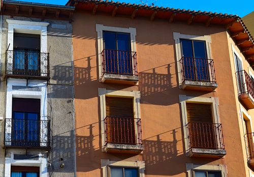 Schatten von metallverzierten Balkonen in der untergehenden Sonne auf einer Fassade in Spanien