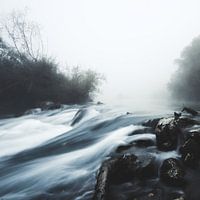 Cascade d'eau par un matin mystique et brumeux