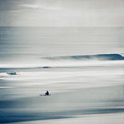 Einsamer Surfer an ruhigem Strand
