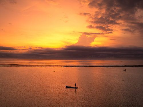 Vissersboot bij zonsondergang op zee