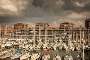 Hafen von Scheveningen voller Boote unter dunklen Wolken
