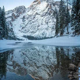 Verschneiter Berggipfel spiegelt sich bei Sonnenaufgang im Pragser Wildsee von t.ART