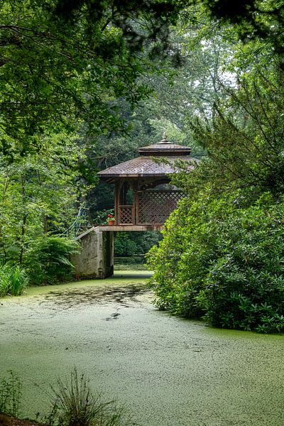 a wooden house in a park on a bridge above the water in a green landscape by ChrisWillemsen