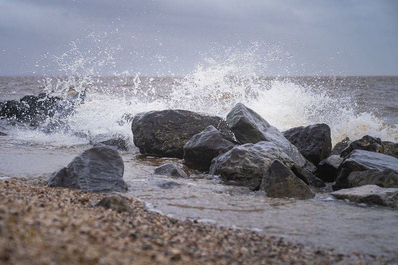 Plätscherndes Meerwasser mit Felsen und Sand im Vordergrund von Margreet Riedstra