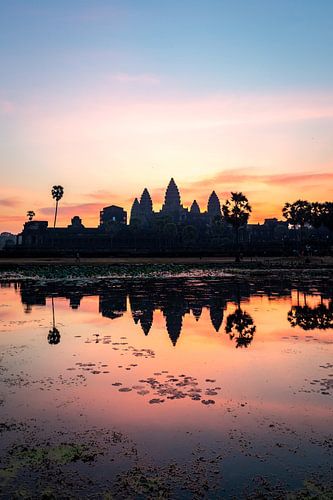 Sunrise with bright colors and a reflection of the Angkor Wat temple in Cambodia.