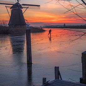 Schaatser op het ijs bij de Molens van Kinderdijk van Maja Mars