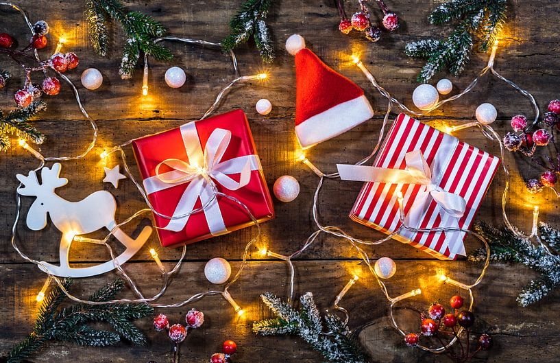 Kerstcompositie met geschenkdozen, kerstmuts, rendier en glimmend licht van Alex Winter