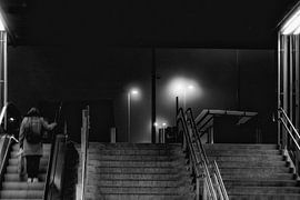 Frau verlässt nachts den Bahnhof Kortrijk