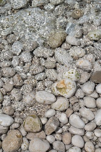 Helder zeewater stroomt over witte stenen 1