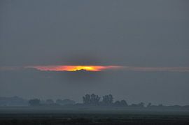 opkomende zon tussen de wolken von Marten Wieringa