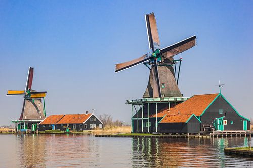 Kleurrijke houten windmolens aan de Zaan rivier in Zaanse Schans, Nederland