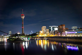 Medienhafen Düsseldorf bei Nacht mit Gehry-Bauten, Rheinturm und beleuchtetem Hafenbecken / Marina von Your Happy Life