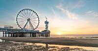 Pier Scheveningen reuzenrad bij zonsondergang vanaf het strand. Weerspiegeling in het water. Zon die