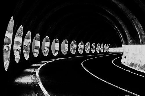 Curved road through a tunnel with side light
