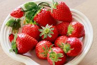 Fresh strawberries with crown on white dish