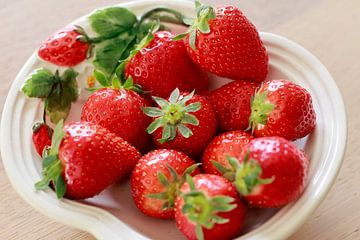 Frische Erdbeeren mit Krone auf weißem Teller von Ans van Heck
