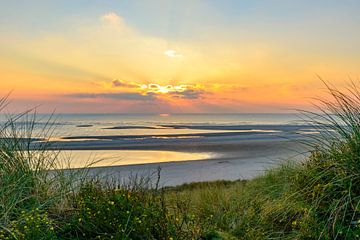 Uitzicht vanaf de duinen tijdens zonsondergang over de Noordzee