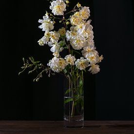 Branche de rose vintage avec des fleurs jaunes et blanches dans un vase en verre. sur Maren Winter