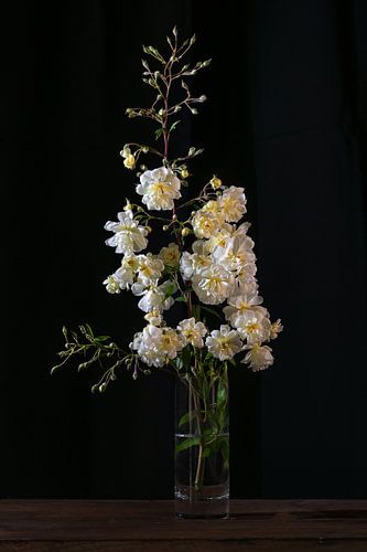 Vintage Rosenzweig mit gelben weißen Blumen in einer Glasvase ag von Maren Winter