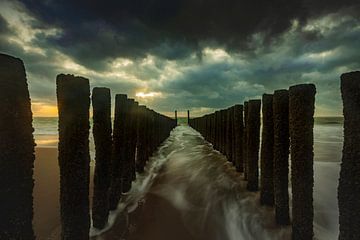 Hollandse wolkenlucht en typische golfbreker van houten palen langs de Zeeuwse kust van gaps photography