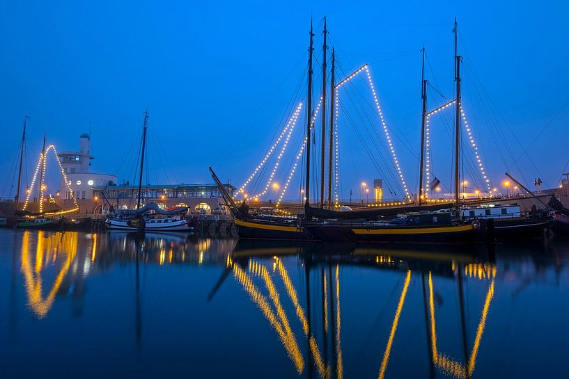 Versierde traditionele boten in de haven van Harlingen bij zonsondergang in Nederland van Eye on You