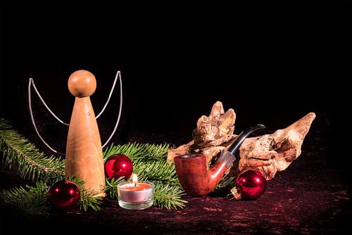Houten engel en pijp gedecoreerd met kerstsparren en kerstboombollen