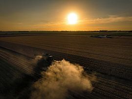 Combine harverster harvesting wheat during summer sunset by Sjoerd van der Wal Photography