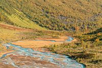 Blue meltwater in autumn valley.