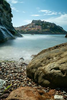 castelsardo sardinie vanaf het strand met rotspartijen