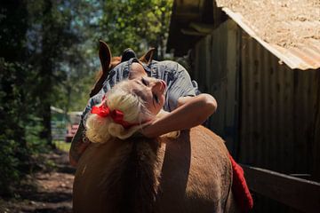 Pinup liegt sexy auf dem Rücken eines Pferdes von Atelier Liesjes