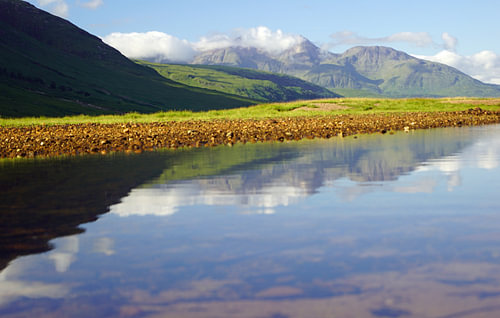 Kleurrijke Glen Etive in Schotland met reflectie van de bergen in de rivier.