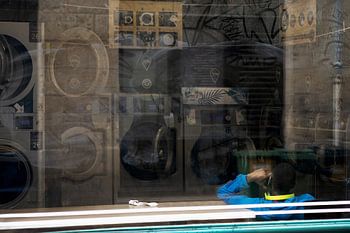 Rufender Mann am Fenster eines Waschsalons