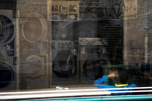 Rufender Mann am Fenster eines Waschsalons