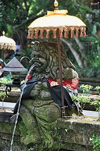 Statuen und Sonnenschirme in einem balinesischen Tempel