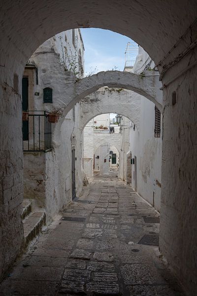 Rue en arc de cercle dans la ville blanche d'Ostuni en Italie par Joost Adriaanse