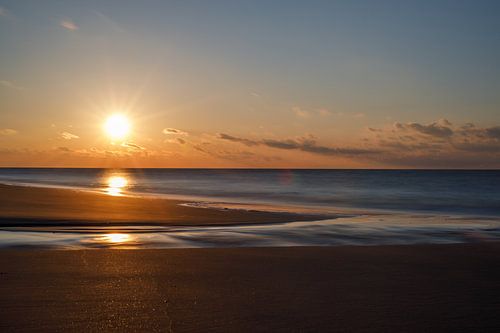 The sun slowly sinks into the sea