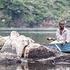Visser rookt een sigaretje op de rivier de Nijl In Uganda van Eric van Nieuwland