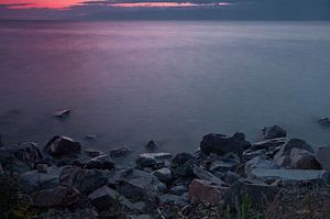 Paysage de coucher de soleil violet avec des pierres sur la rive du lac Baïkal en Sibérie