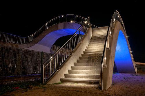 Illuminated bridge over rail tracks for pedestrians