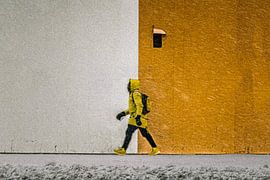 Photo de rue symétrique d'un homme marchant dans le blizzard et les couleurs vives.